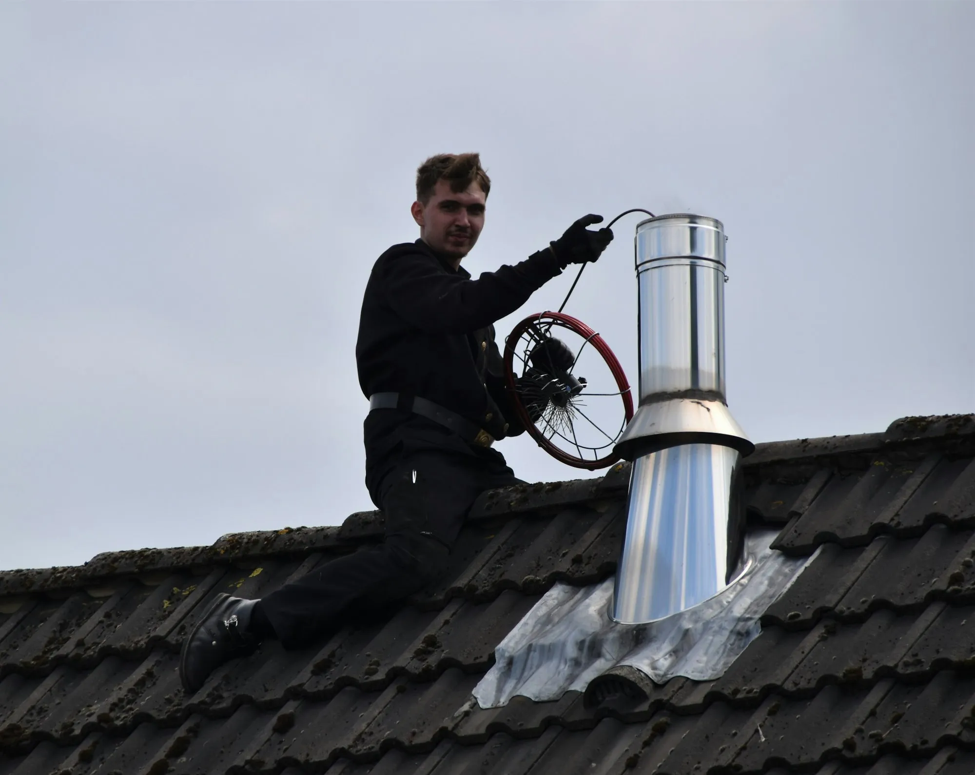 Schornsteinfeger bei der Arbeit auf einem Wohnhausdach